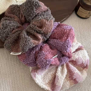 Three-pack knitted wool scrunchies in mixed colors on a cozy decorative tray