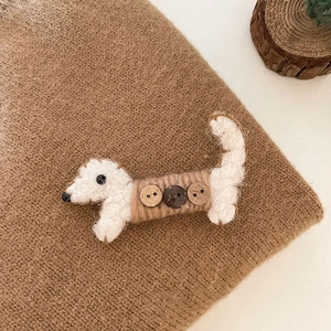 Détail de la pince à cheveux datchshund en peluche avec texture laine et boutons en bois