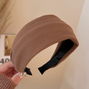 Macro shot of the coffee brown thick headband showing sand-like grainy fabric texture