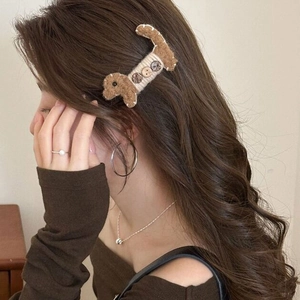 Détail de la pince à cheveux teckel en peluche marron avec boutons décoratifs