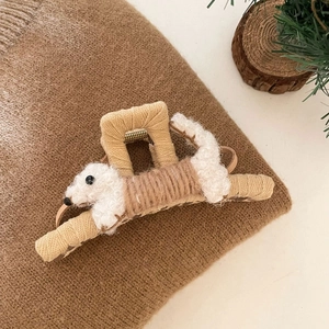 Détail d'une pince à cheveux peluche chien avec texture tissée beige pour un look hivernal