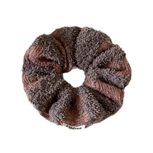 Plush knitted oversized scrunchie in gray and brown tones with woven brand label