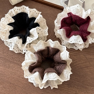Lace-trimmed knitted scrunchie set in black, wine red, and coffee on a wooden desk