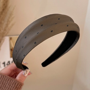 Close-up of wide brown polka dot headband with retro textured fabric and non-slip lining