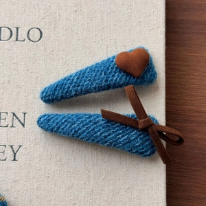Détail de pinces à cheveux BB en tricot bleu avec cœur et nœud marron