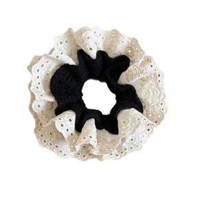 Elegant knit scrunchie with white lace trim and black pleated fabric on white background