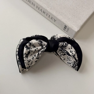 Detail of French vintage hair claw featuring black and white floral print bow fabric
