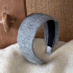 Détail du serre-tête en laine grise avec doublure antidérapante noire et finitions tressées