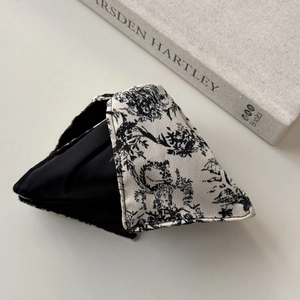 French vintage black and white ink print bow hair clip on a minimalist gray background