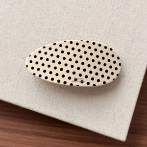 Detailed close-up of oval marble pattern hair clip with gold Barrette La France lettering