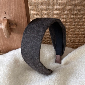 Détail de la texture en laine grise et de la doublure noire du serre-tête épais