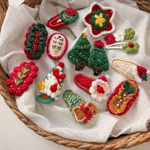 Handmade crochet Christmas hair clips featuring Santa and tree designs on white linen