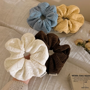 Set of 4 solid color knitted scrunchies in cream, blue, yellow, and coffee brown