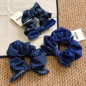 Three-piece set of blue bow hair scrunchies in denim, plaid, and polka dot cotton fabric