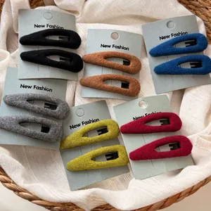 Lot de 6 barrettes goutte en velours de couleurs variées dans un panier tressé