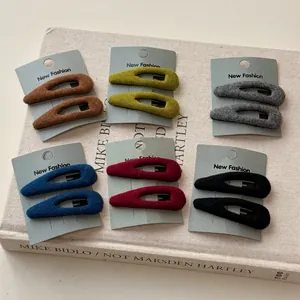 6 paires de barrettes BB en velours en forme de goutte en couleurs assorties sur un livre