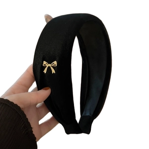 Classic black velvet headband with a delicate gold bow accent for a vintage look