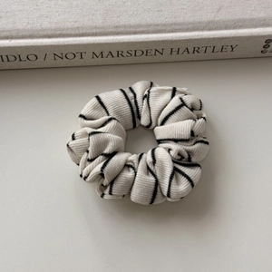 Detailed view of black and white striped knit fabric scrunchie with ribbed texture