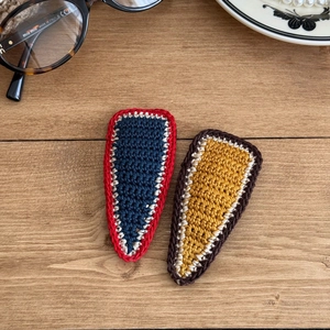 Handmade crochet knit hair clips in contrast colors for women on wood background