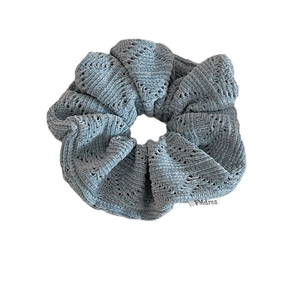 Solid blue-gray knit scrunchie with soft hollow-out crochet texture and side fabric label