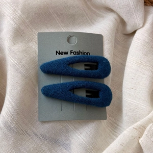 Détail de barrettes goutte en velours bleu marine sur carte pour coiffure tendance