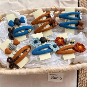 Chic knit flower hair clips set in Klein blue and caramel brown colors with 3D bear decoration