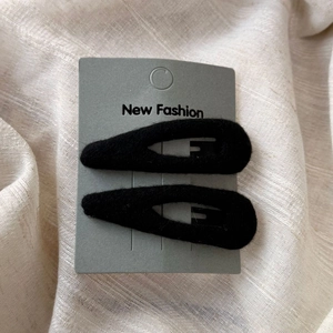 Détail de deux barrettes goutte d'eau en velours noir sur carte New Fashion