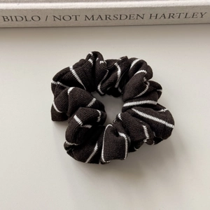 Detail of black and white striped knit scrunchie texture on a minimalist background