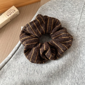 Close-up of a vintage brown knitted striped scrunchie with soft woolly texture