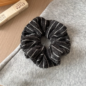 Detailed view of black and white striped knitted scrunchie on textured background