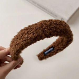 Detail of dark brown faux shearling headband featuring a soft handmade inner label