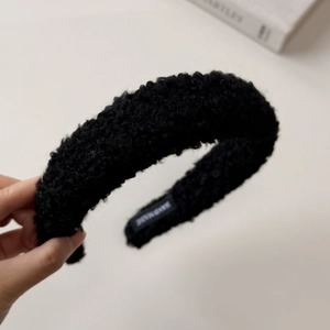 Detailed close-up of handmade black lamb wool headband featuring fluffy plush texture
