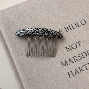 Detail view of handmade leopard acetate hair comb with golden France lettering