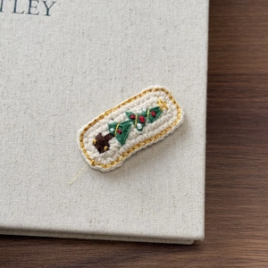 Détail d'une pince à cheveux en crochet faite main avec broderie festive de sapin de Noël