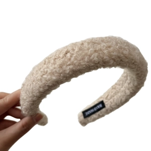 Plush beige faux lamb wool headband with handmade label for elegant high-top styling