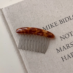 Detailed macro view of handmade amber resin hair comb with durable ten-tooth metal comb pins
