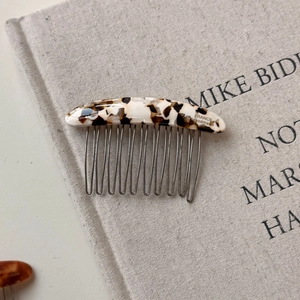 Close-up of handmade cream tortoiseshell acetate hair comb with silver metal teeth
