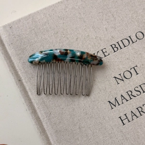 Detailed view of handmade acetate hair comb with ten silver metal teeth and tortoiseshell pattern