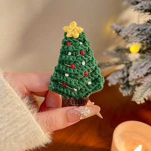 Détail de la pince à cheveux sapin de Noël au crochet fait main avec étoile festive