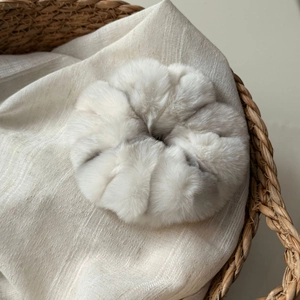 Détail macro d'un chouchou en fausse fourrure douce et pelucheuse dans un panier tressé