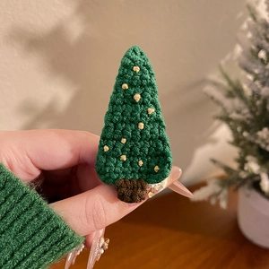 Détail d'une pince à cheveux sapin de Noël au crochet faite main avec ornements