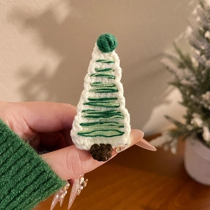 Vue détaillée de la pince à cheveux sapin de Noël tricotée main avec des pompons verts