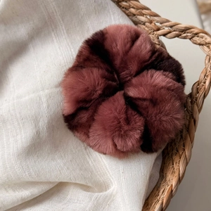 Détail d'un chouchou géant en fausse fourrure pelucheuse, rose poudré et marron