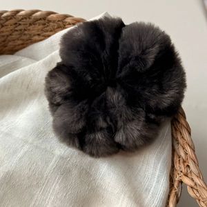 Gros plan d'un chouchou en fausse fourrure noire dans un panier pour un style cocooning