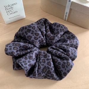 Dettaglio di un morbido elastico leopardato in viola scuro e marrone vellutato