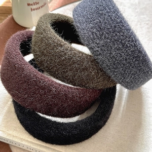 Plush wool wide headband set in four autumn colors displayed on books with a cup