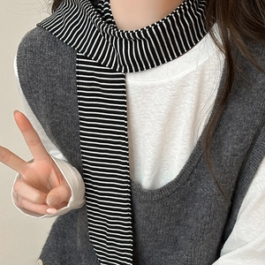Classic black and white striped knit scarf paired with a grey vest for winter layering
