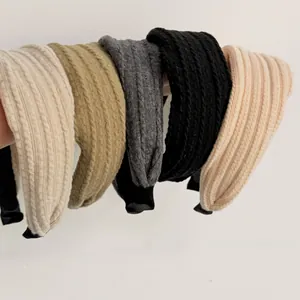Gros plan de cinq bandeaux larges tricotés en beige, kaki, gris, noir et orange