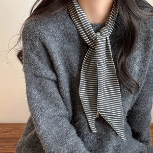 Elegant grey and white striped skinny scarf for women styled with a grey knitted sweater