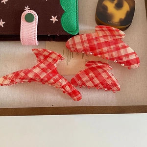 Three-piece red and white plaid acetate shark hair claw set displayed on a tray